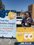 One of the 2019 Golden Soapy winners holding a Golden Soapy Joe's air freshener.