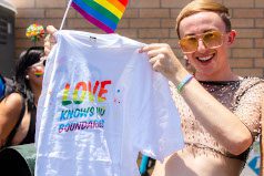 Pride participant holding their Soapy Joe's Pride tee that says 'Love knows no boundaries.