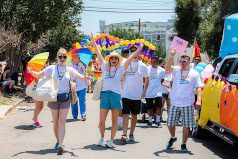 Soapy Joe's team members holding rainbow items walking in the 2019 Pride Parade.