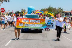 Soapy Joe's team members walking in the 2019 Pride Parade holding a banner that says 'Love knows no boundaries.