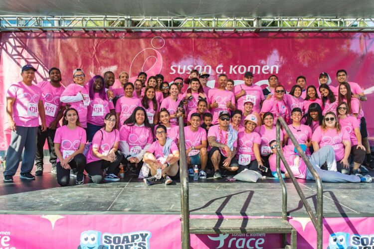 Soapy Joe's team members wearing pink shirts in front of a Susan G. Komen Race for the Cure banner.