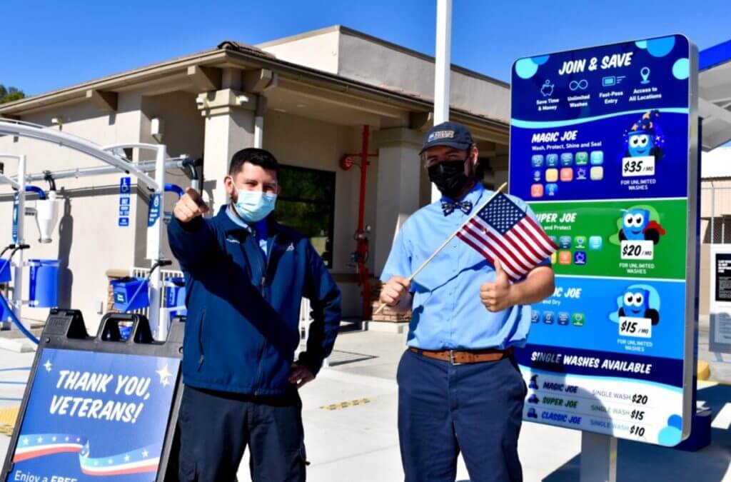 Two Soapy Joe's team members, one waving an American flag, outside during our 2020 Veteran's Day event.